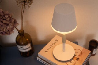 Hue Go Table Lamp sitting on books